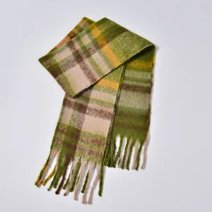 Macro detail of thick checkered scarf with green and yellow wool fringe texture