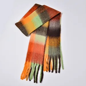 Close-up of thick rainbow plaid scarf featuring soft brushed texture and long tassels