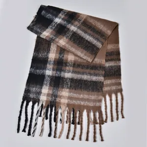 Close-up of thick plaid scarf featuring brown and black checkered patterns with long tassels