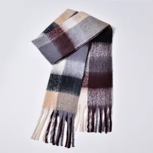 Close-up of rainbow plaid scarf showing thick bouclé yarn texture and tassel fringe details