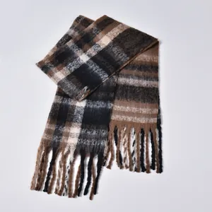 Detail of classic thick checkered scarf with tassel fringe in brown and black