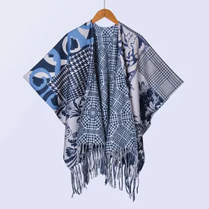 Detail eines böhmischen Strick-Ponchos mit Tusche-Muster und eleganten Fransen am Saum