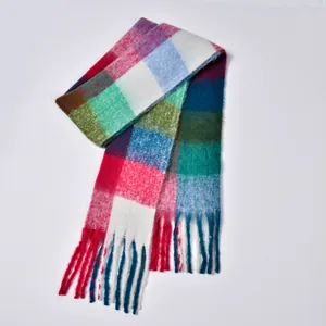 Macro detail of rainbow plaid pattern and thick tassels on a warm winter scarf