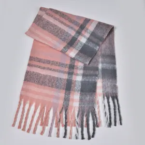 Close-up of thick plaid boucle scarf with pink and grey pattern and soft tassel fringe
