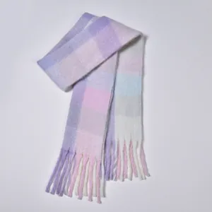 Detail of soft pastel rainbow plaid scarf featuring thick brushed texture and chunky tassels