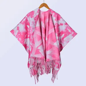 Detail eines rosa Batik-Schals mit Quastenfransen auf einem Holzkleiderbügel