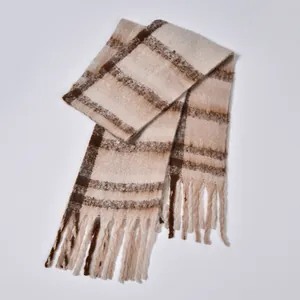 Close-up of thick checkered scarf with soft boucle yarn texture and long fringe detail