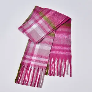 Detail of soft thick boucle yarn plaid scarf with rose red fringes and vibrant colors