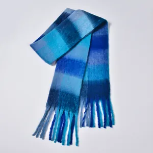 Close-up of thick rainbow plaid scarf featuring soft blue gradient tassels and plush texture