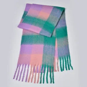 Close-up of rainbow plaid scarf with purple and pink thick yarn textures and soft tassels