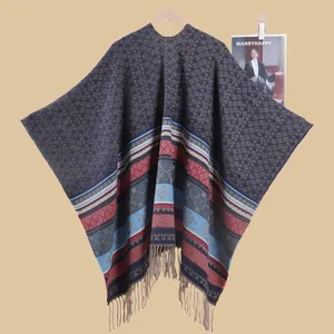 Detail of bohemian geometric knit shawl featuring blue diamond patterns and fringe trim