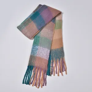 Detailed macro shot of the rainbow plaid scarf showing soft fuzzy texture and tassels