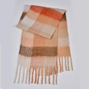 Detailed view of the soft bouclé yarn texture and tassels on the thick rainbow plaid scarf