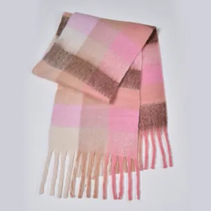 Close-up of thick plaid scarf texture with soft tassels and pink mohair-like fabric