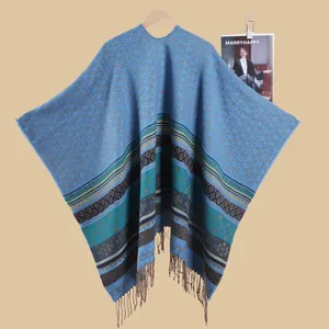 Detail view of ethnic geometric jacquard poncho with fringe trim and blue diamond patterns