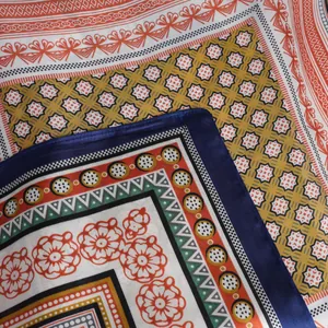 Detail shot of vintage geometric print silk scarf showing satin texture and floral patterns