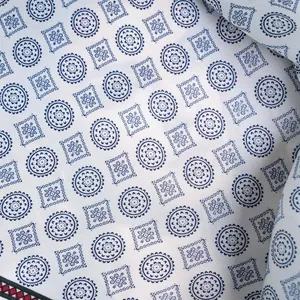 Detail of premium satin silk fabric showing blue floral print and fine edge stitching