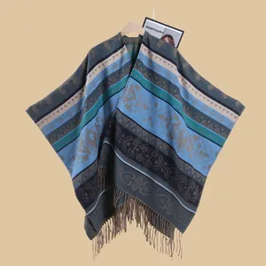 Close-up of bohemian knit poncho with ethnic jacquard patterns and long fringe details