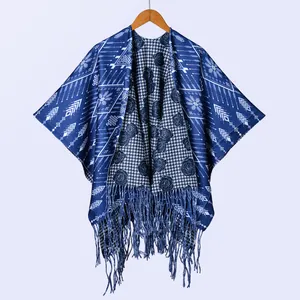 Detail eines dicken dunkelblauen Ponchos mit geometrischen Mustern und langen Fransen