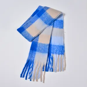 Close-up of thick blue and beige plaid scarf with soft fringe and textured yarn