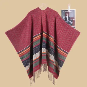 Close-up of retro geometric rhombus patterns and fringe tassels on a dark red shawl