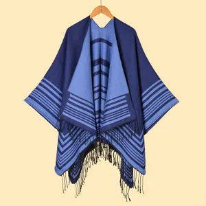 Women's blue striped knit poncho with fringe details and V-shaped geometric patterns