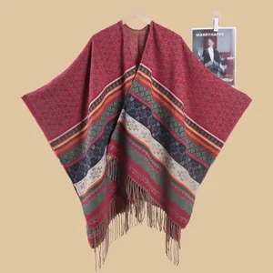 Detail of red geometric knit shawl featuring bohemian patterns and long fringe tassels