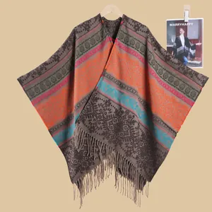 Detail of bohemian knit poncho with floral jacquard patterns and fringe trim edges