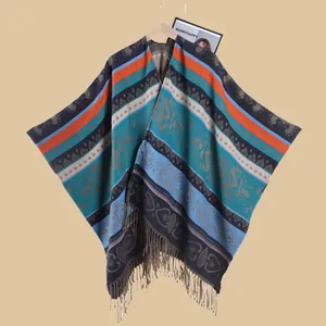 Detailed close-up of ethnic jacquard pattern and long tassel hem on women cloak