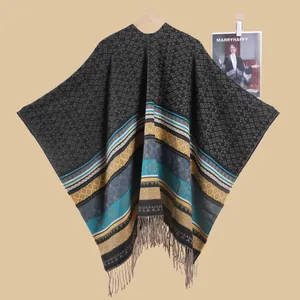 Detail of bohemian knit shawl with geometric patterns and soft grey fringe tassels