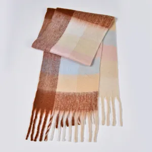 Detail of colorful rainbow plaid scarf featuring caramel brown hues and soft tassels