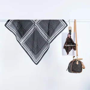 Détail du foulard carré en satin à motif cœur avec pois et rayures noir et blanc