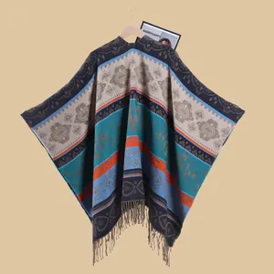 Detail of bohemian jacquard knit poncho with heart patterns and fringe tassels