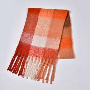 Detail of warm rainbow plaid scarf featuring thick textured yarn and long fringe tassels
