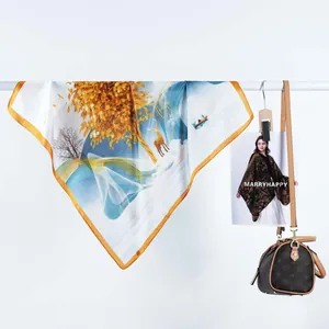 Gros plan d'un foulard satiné montrant des imprimés de rennes et de paysages dorés