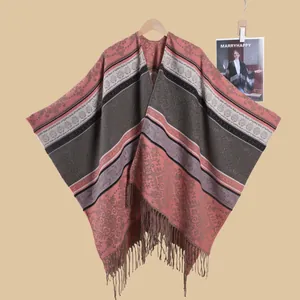 Detail of vintage ethnic knit shawl showing intricate floral patterns and soft fringe trim