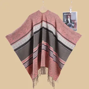 Detail of vintage knit shawl with floral patterns and long tassels on a wooden hanger