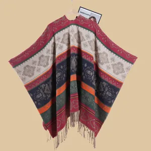 Detailed view of bohemian floral jacquard pattern and fringe on ethnic knit cape
