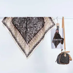 Détail d'un foulard carré en satin rétro avec des motifs floraux marron vintage