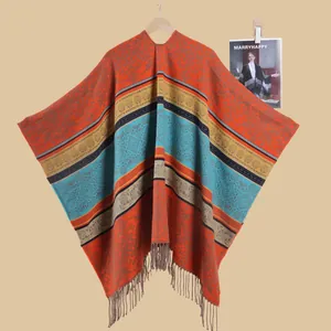 Close-up of vintage knit shawl with vibrant orange stripes and bohemian tassel fringe