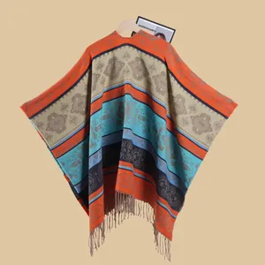 Detail of bohemian ethnic poncho with colorful geometric patterns and long tassel fringe