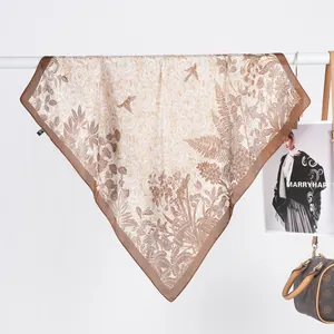 Detail of floral printed satin square scarf with bird pattern and brown borders