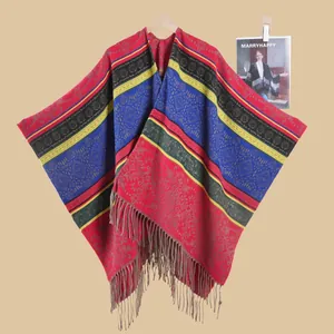 Detail of bohemian knit shawl with colorful vintage floral patterns and brown tassels