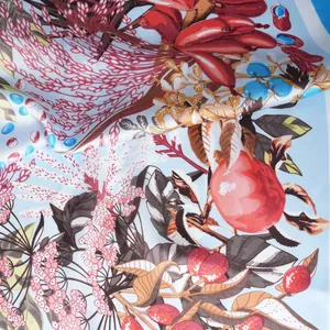 Gros plan d'un foulard en satin soyeux avec des imprimés botaniques et tons bleu doux