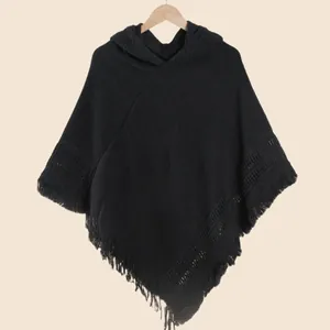 Détails d'un poncho noir en tricot à capuche avec de longues franges élégantes en bas