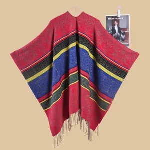 Close-up of red bohemian shawl with intricate paisley patterns and long grey fringes