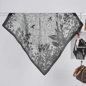 Detail of square satin scarf showing monochrome floral prints and black contrast borders