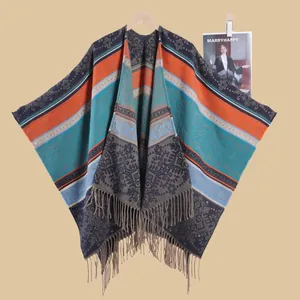 Close-up of bohemian knit shawl with geometric patterns and long tassel fringe