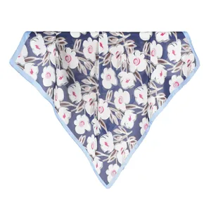 Navy blue silk scarf with white floral print and light blue border in a folded hanging view