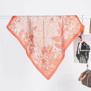 Detailed close-up of orange floral bird pattern on elegant satin silk square neck scarf